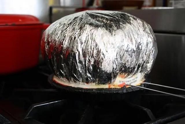 A classic sight: Jiffy Pop's foil dome expanding as the popcorn pops inside, a nostalgic reminder of homemade stovetop popcorn