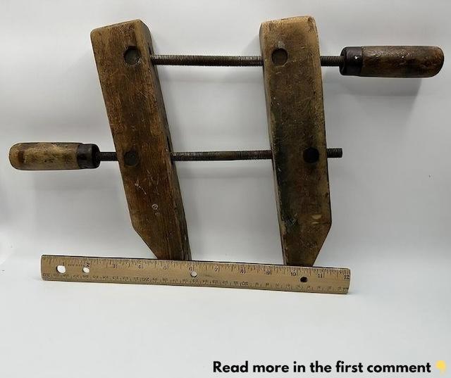 A well-used vintage adjustable wood clamp showing its worn, rustic handles and strong iron screws that once held countless woodworking projects in place.